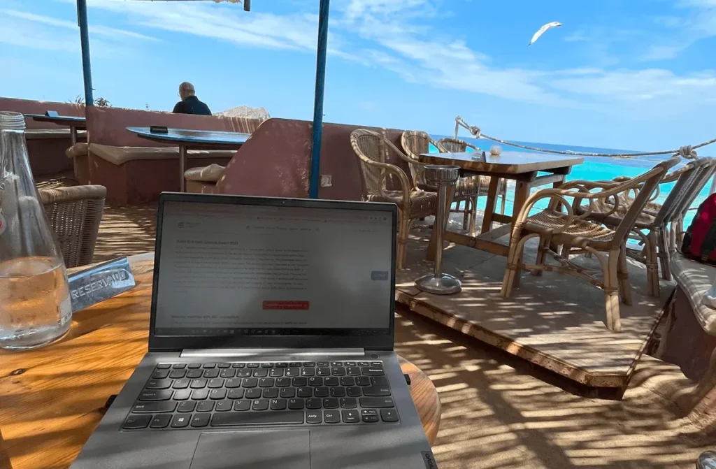 picture of a laptop and a beach on the background